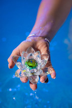 Woman holding fragile lotus flower. Clean water drops are dripping from crystal. Concept of religion, kundalini, meditation, chakras, spiritual inner world. High quality photo