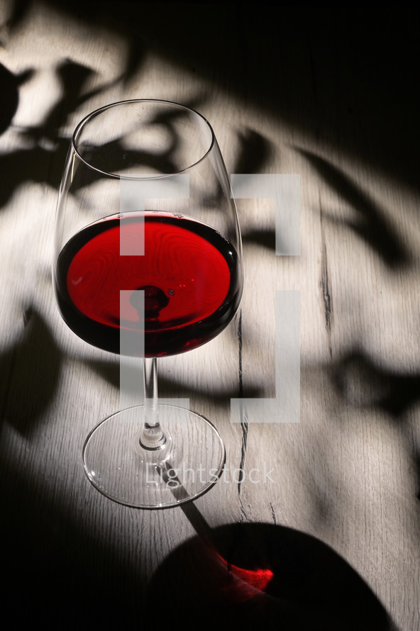 Wine glass on table with shadows
