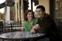 man and woman sitting at a cafe table