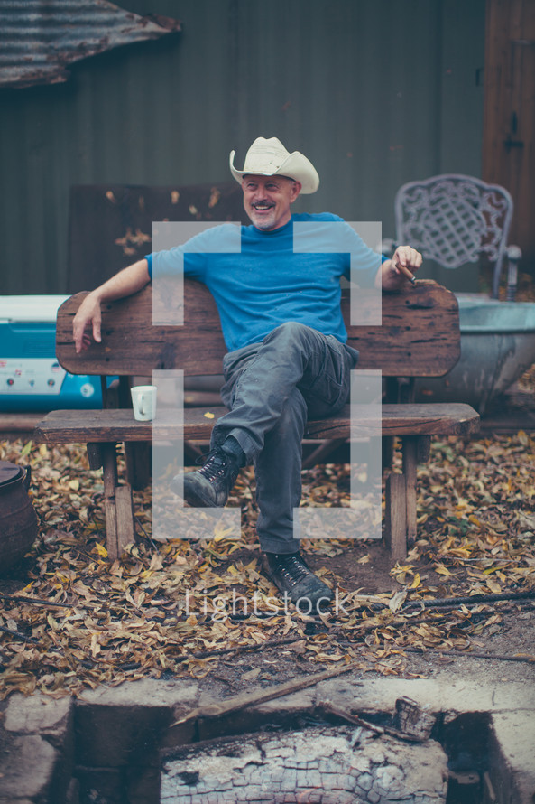 man in a cowboy hat smoking a cigar 