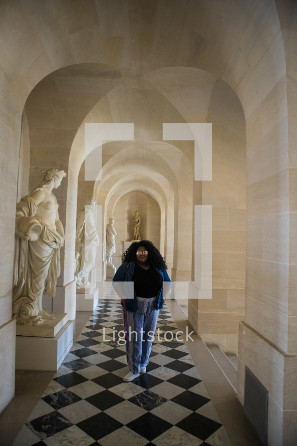 A woman standing in the halls of the Vatican 
