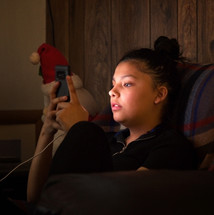 teen girl looking at a cellphone screen 