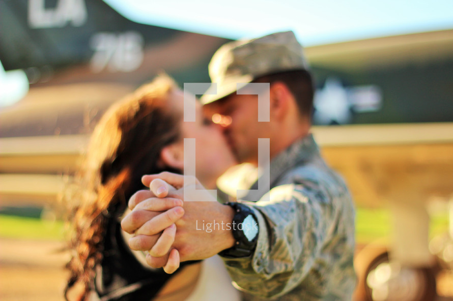 a military couple kissing 