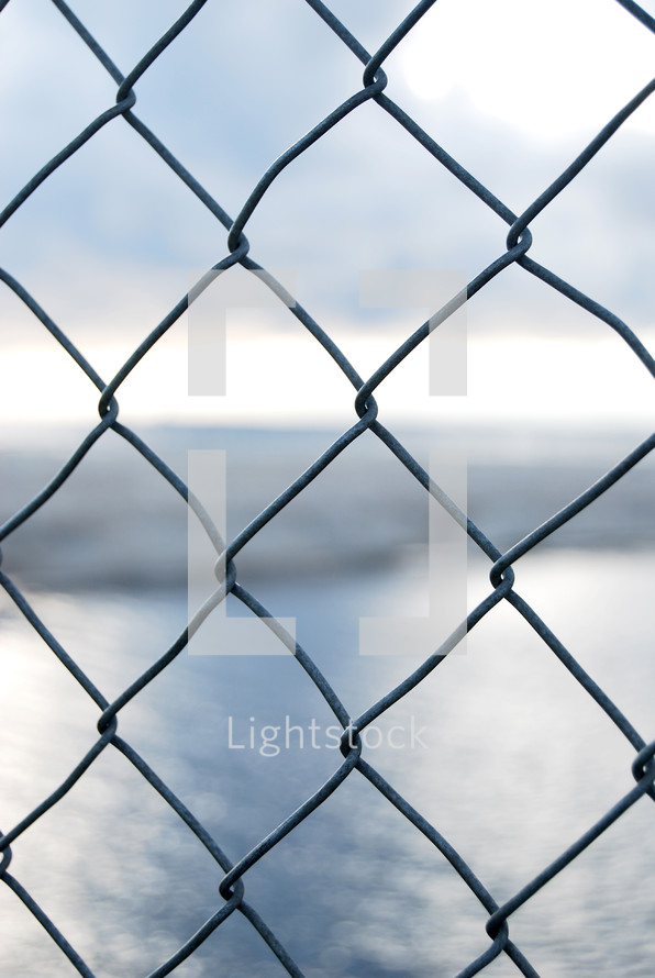 view of water through a chain link fence 