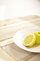 Two halves of a lemon on a white plate
