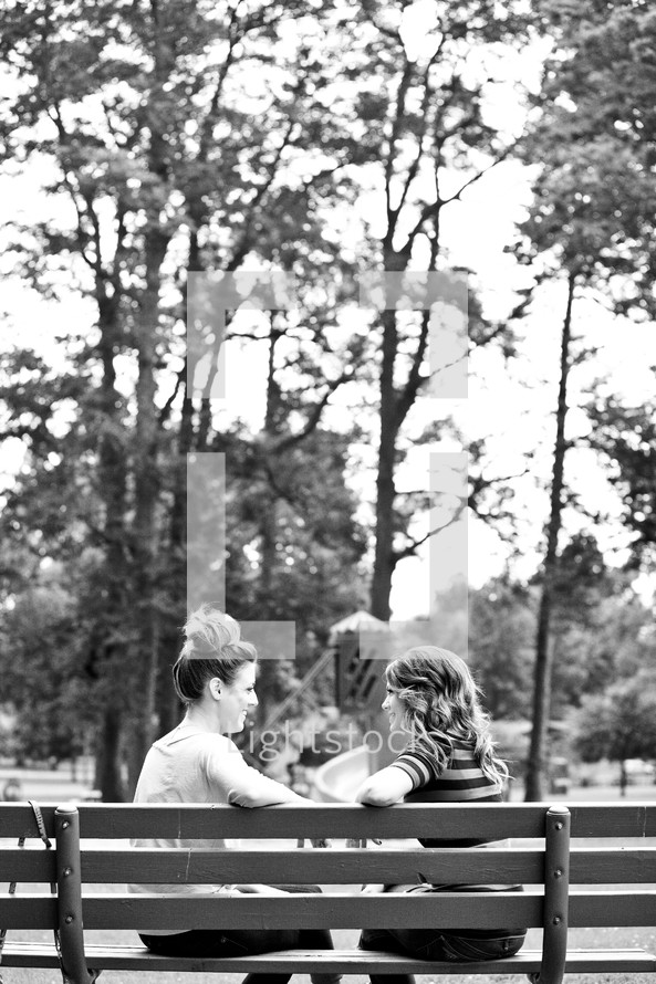 friends in conversation on a park bench 