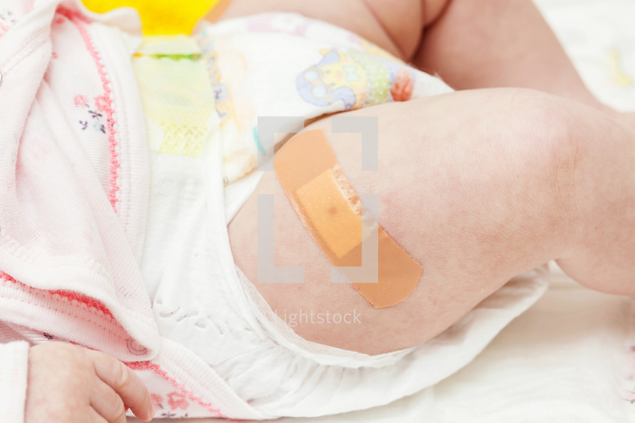 leg of a newborn with the patch after vaccination