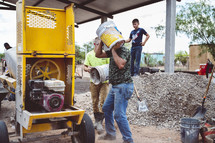 men carrying buckets at a construction site 