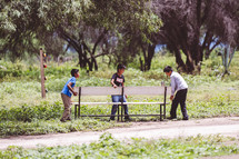 kids moving a bench outdoors in Mexico 