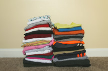 Stacks of folded clothing for boys and girls on the floor