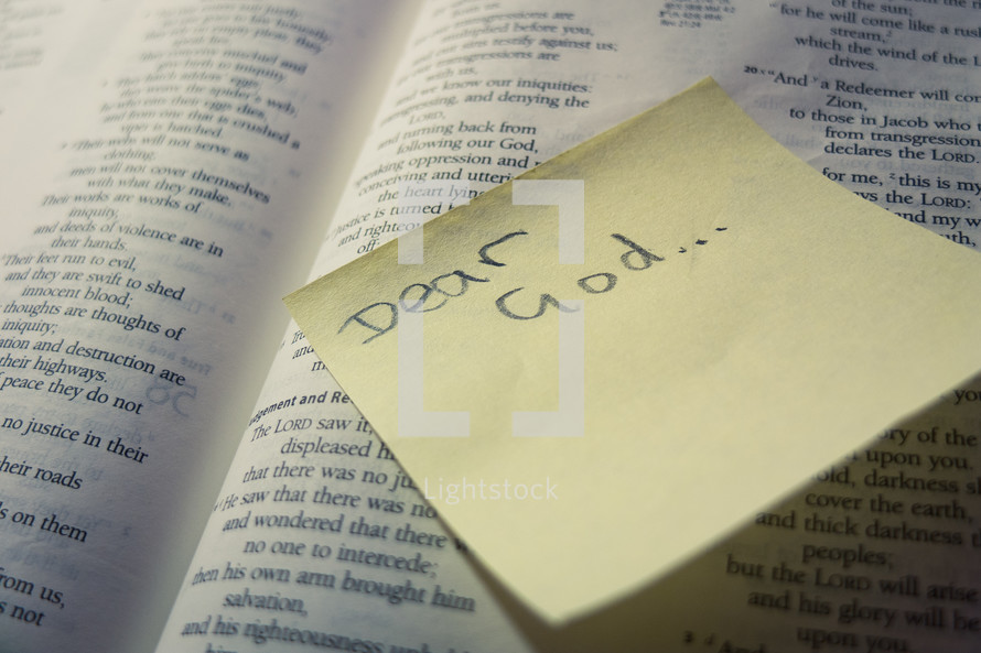 A post-it sticky note with 'Dear God' stuck to a page of an open bible