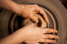 hand on clay on a potter's wheel 