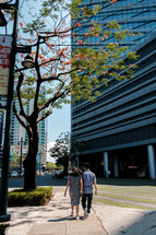a couple walking on a city sidewalk 