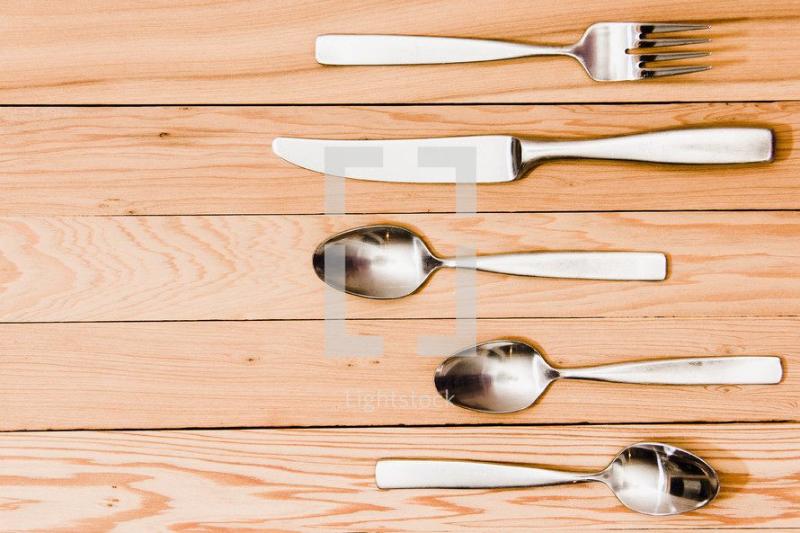 fork, knife, spoons, on a wood floor 