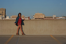 a woman walking at the top of a parking garage 