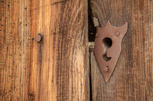 A keyhole on old wooden doors.