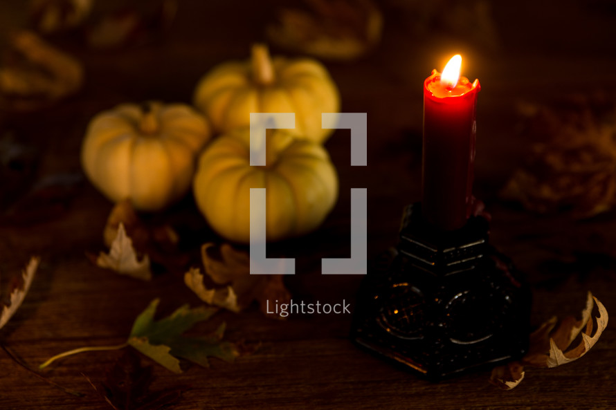 a candle with fall pumpkins