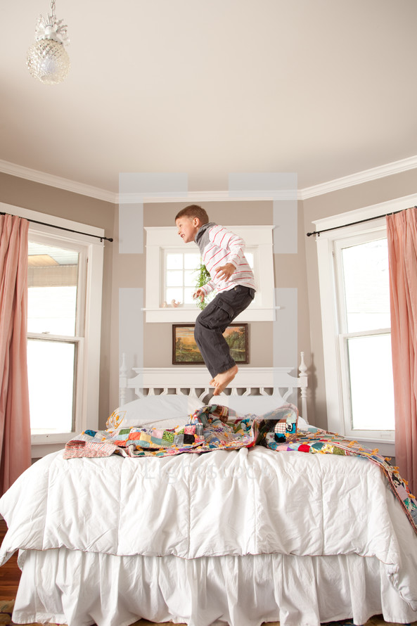 little boy jumping on the bed