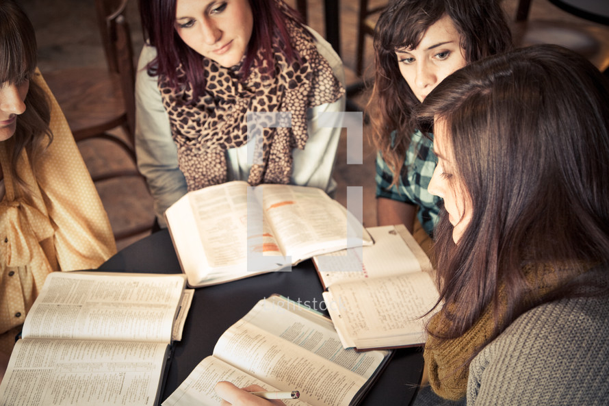 group of young women reading and discussing scripture at a Bible study