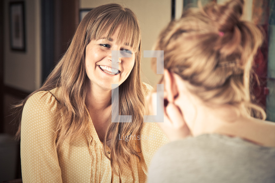smiling woman talking to another woman at a Bible study
