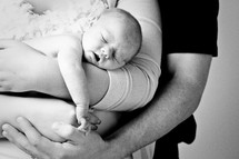 mother and father cradling a newborn