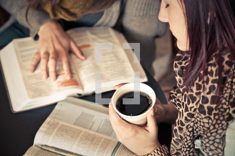 young woman holding a cup of coffee as she read and discusses scripture at a Bible study