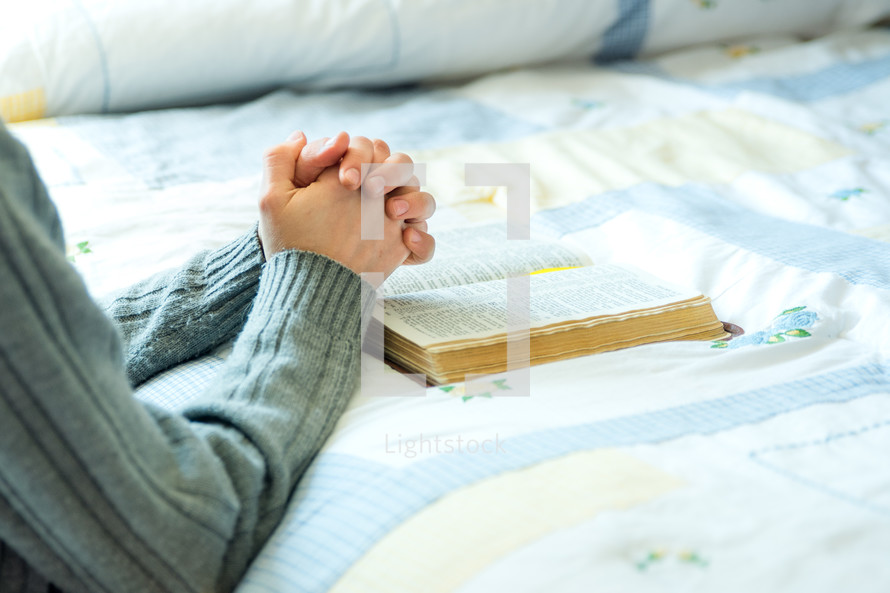 praying beside the bed with a bible