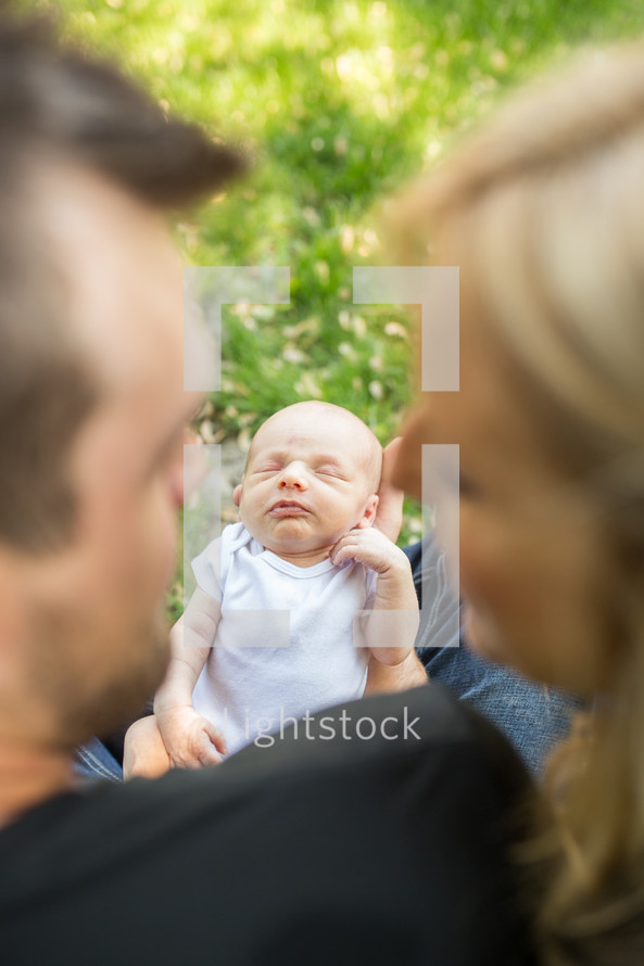 new parents holding a newborn baby 