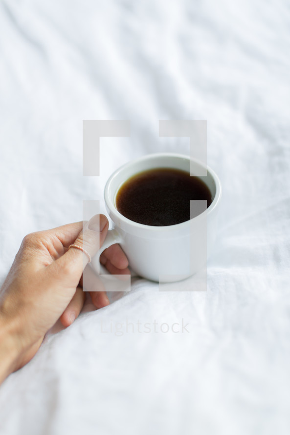 hand holding a coffee cup handle 