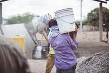 men carrying buckets at a construction site 