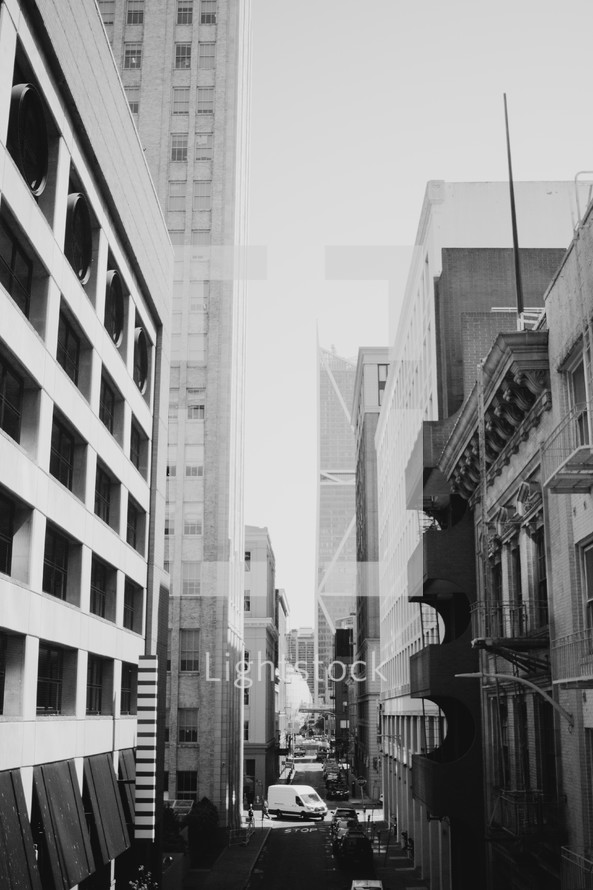 narrow street between tall buildings in a city 