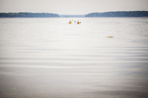 kayakers paddling on a lake 