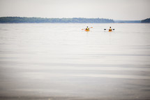 kayakers paddling on a lake 