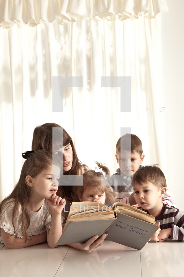 mother reading Bible stories to her children
