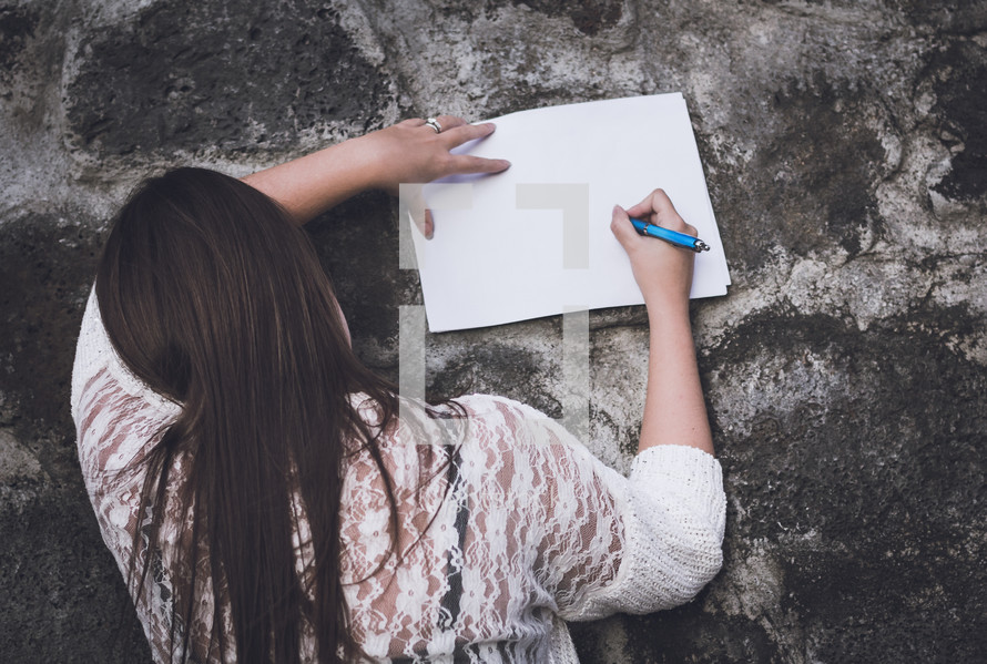a teen girl drawing on blank paper 