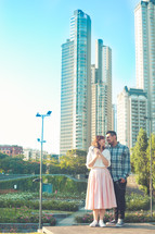 a couple standing together in front of a city 