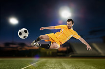 Man kicking a soccer ball on a soccer field