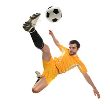 Young man in a yellow uniform kicking a soccer ball
