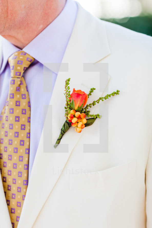 mens orange floral on a lapel white suit yellow tie