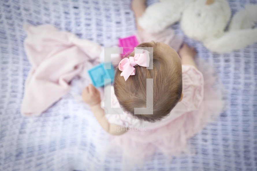 Infant baby girl playing on blanket