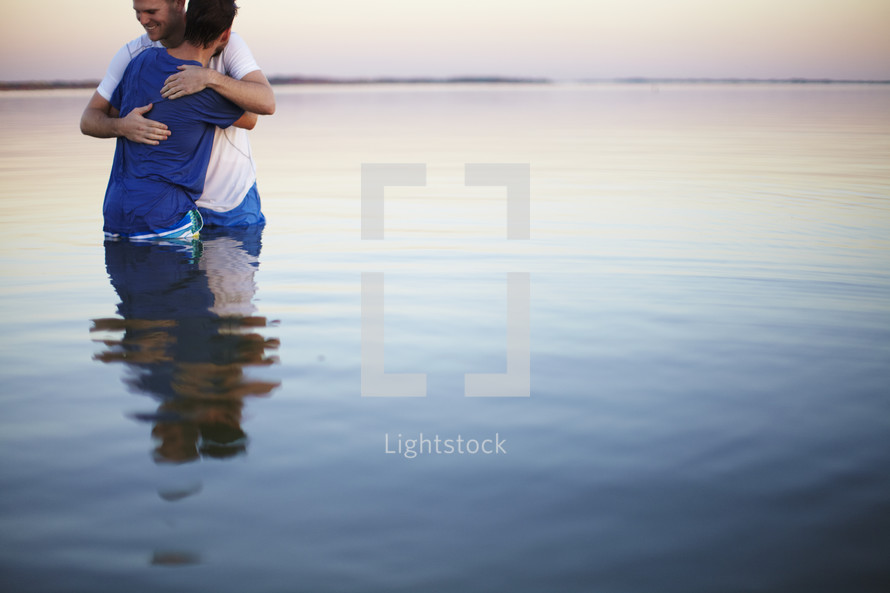 Two men embrace after being Baptized