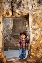 smiling toddler boy in a cowboy hat 