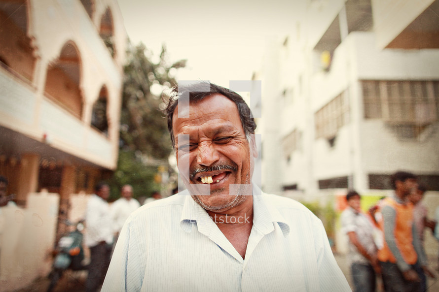 man in India smiling standing in a city alley