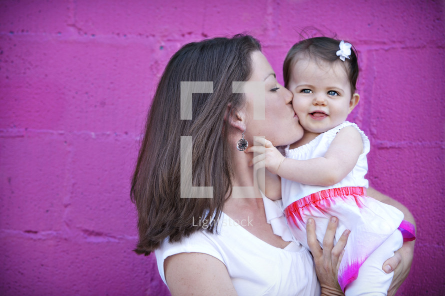 mother kissing her infant daughter's cheek