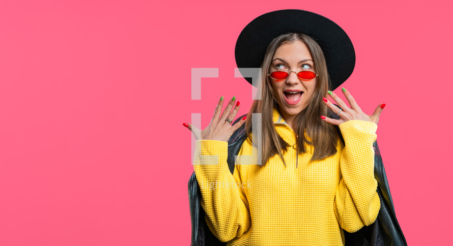 Amazed woman, she expresses WOW. Impressed teenager trying to get attention. Concept of sales, profitable offer. Excited stylish girl on pink background. High quality