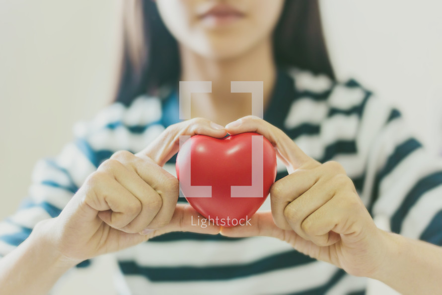 girl holding a red heart 