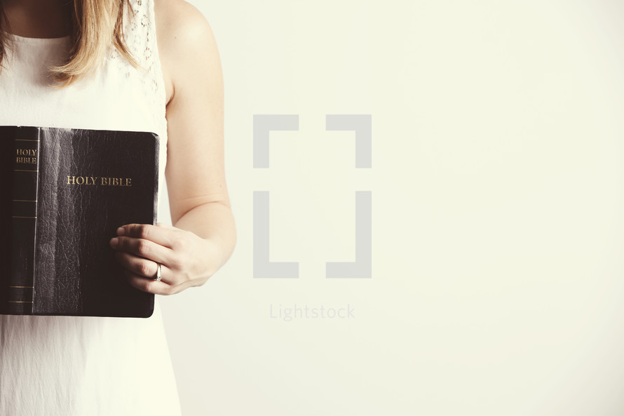 Woman holding an open black, leather Holy Bible.