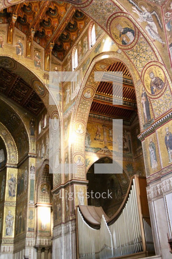 organ pipes and artwork on a cathedral ceiling 