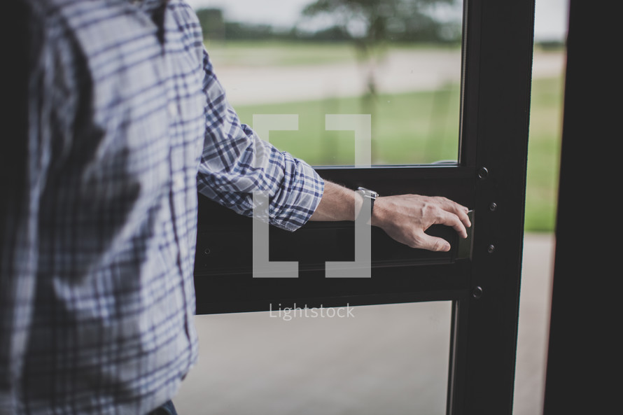 man holding open the door of a church 