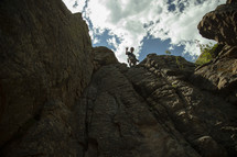 rock climber standing at the edge of a cliff 